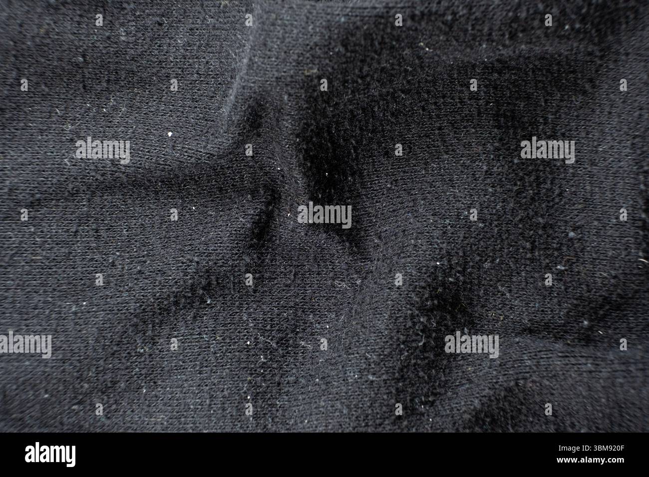 Old worn-out fabric with damaged structure, protruding threads Stock Photo