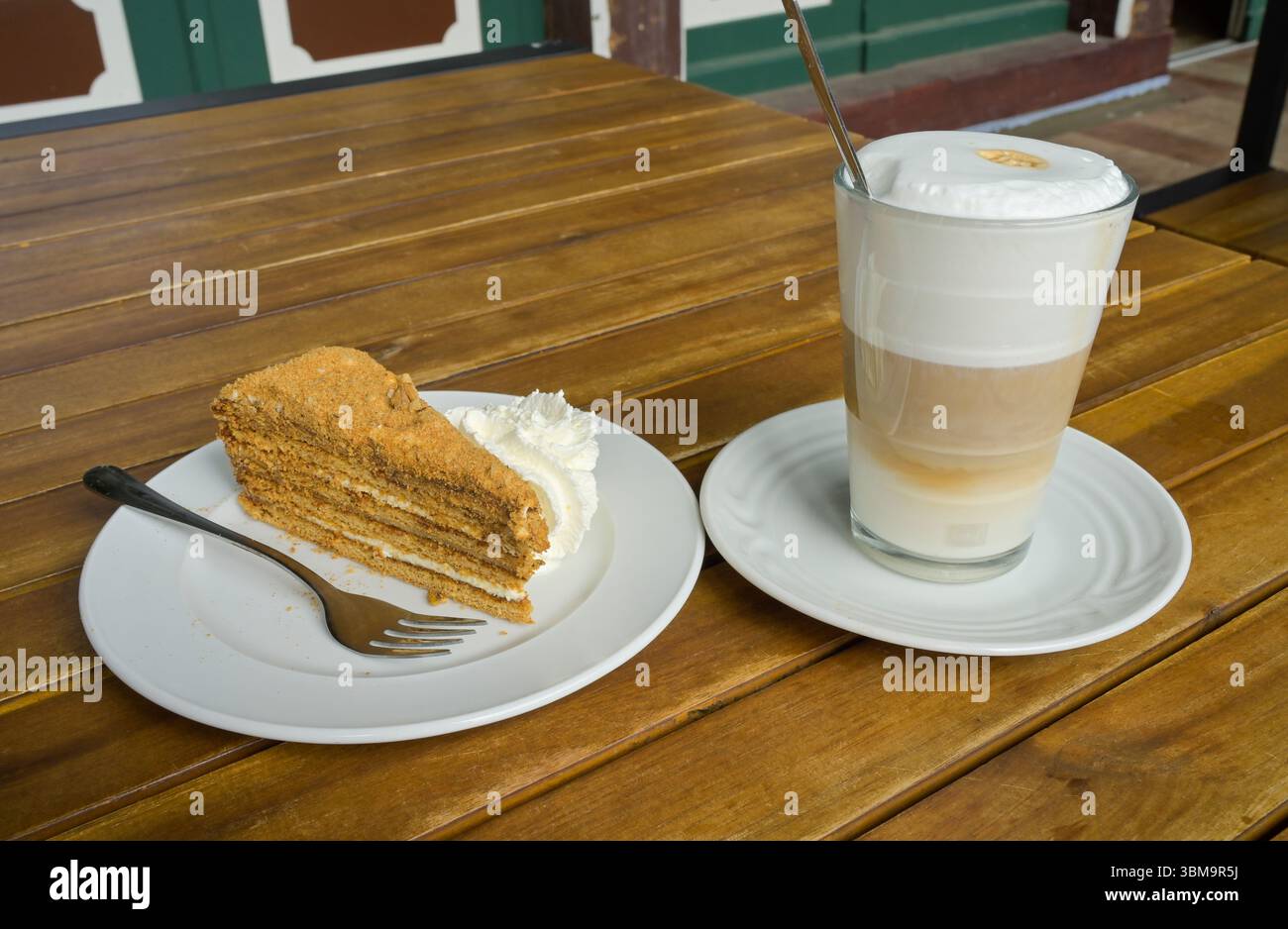Teller Nusstorte mit Sahne, Glas Latte macchiato Stock Photo