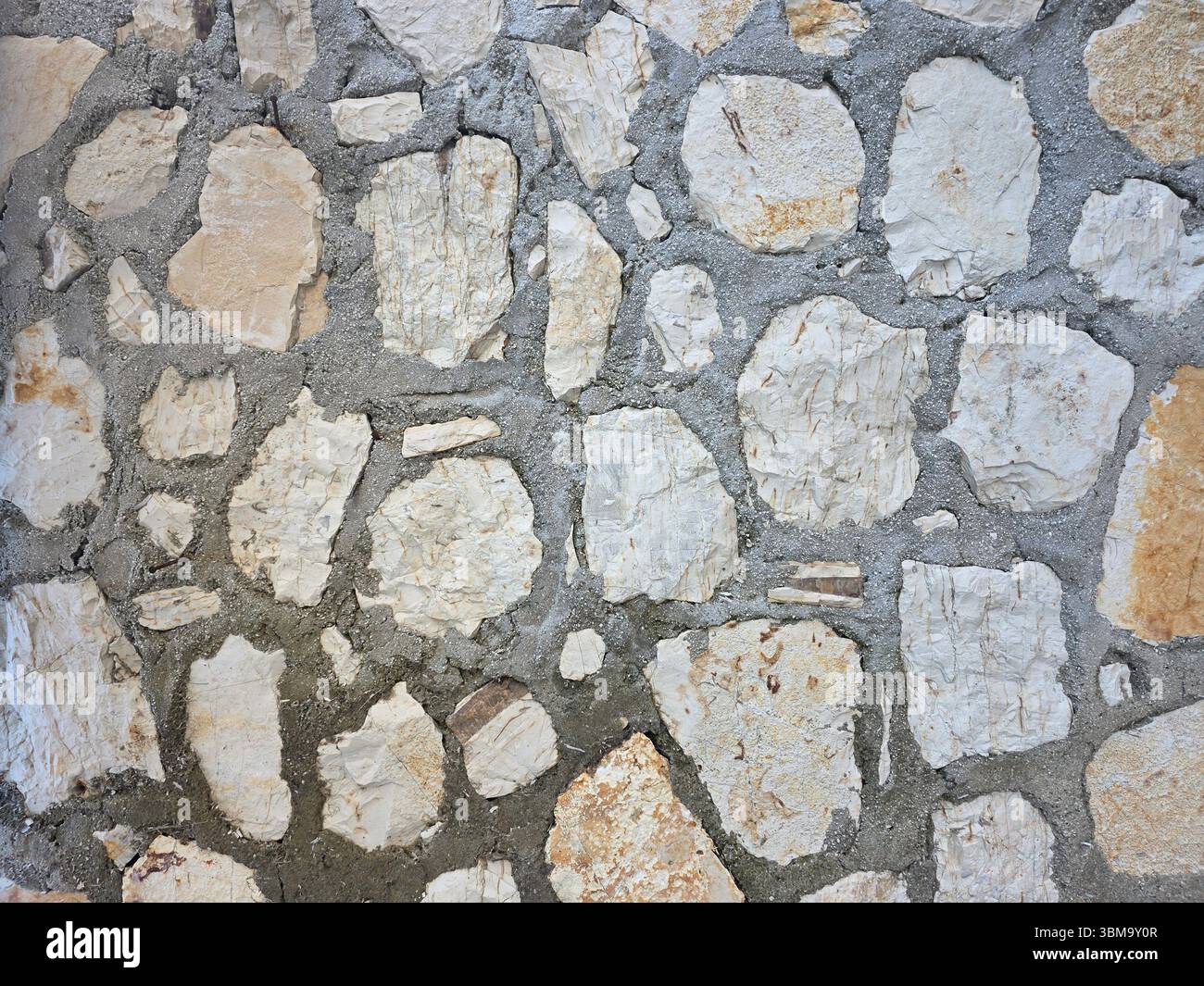 A traditional stone wall texture, creating a natural and rustic background pattern. Stock Photo