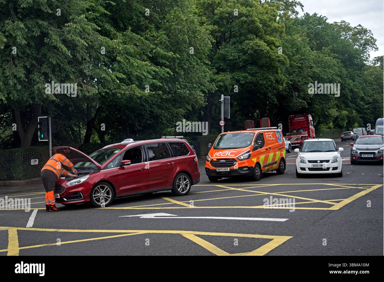 RAC patrolman attending a broken down vehicle in the middle of the road in Queen Street, Edinburgh, Scotland, UK. Stock Photo