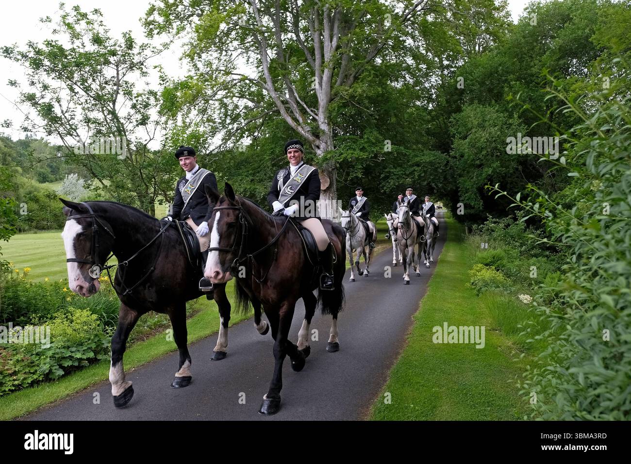 Galashiels, UK. 25th June, 2025. The Braw Lads Gathering, Torwoodlee ride-out, during which the Principals and mounted supporters undertake the traditional visit to Torwoodlee estate, and visit the Laird of Gala, and seek to take a 'Sod & Stone' from the Tower on the Estate to be used at the Ceremonies on Braw Lads Day later in the week. Braw Lads Gathering 2025, Braw Lad Cameron Brydon, Braw Lads Gathering 2025, Braw Lass Hannah Scott lead the cavalcade outwards to Torwoodlee. Credit: Rob Gray/Alamy Live News Stock Photo