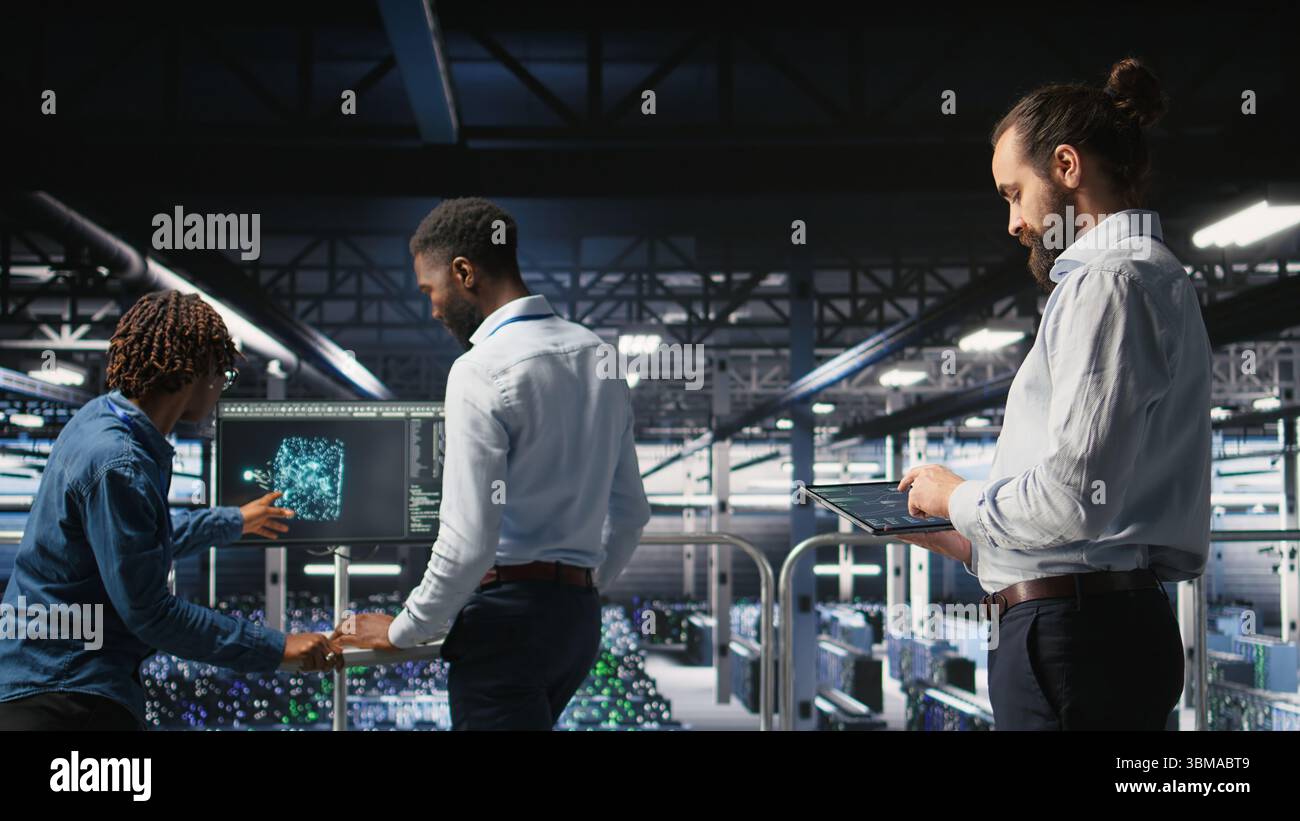 Programmers on data center industrial platform checking code on tablet, doing software updates. Server farm IT professionals cooperating, finetuning rackmounts configurations, Stock Photo