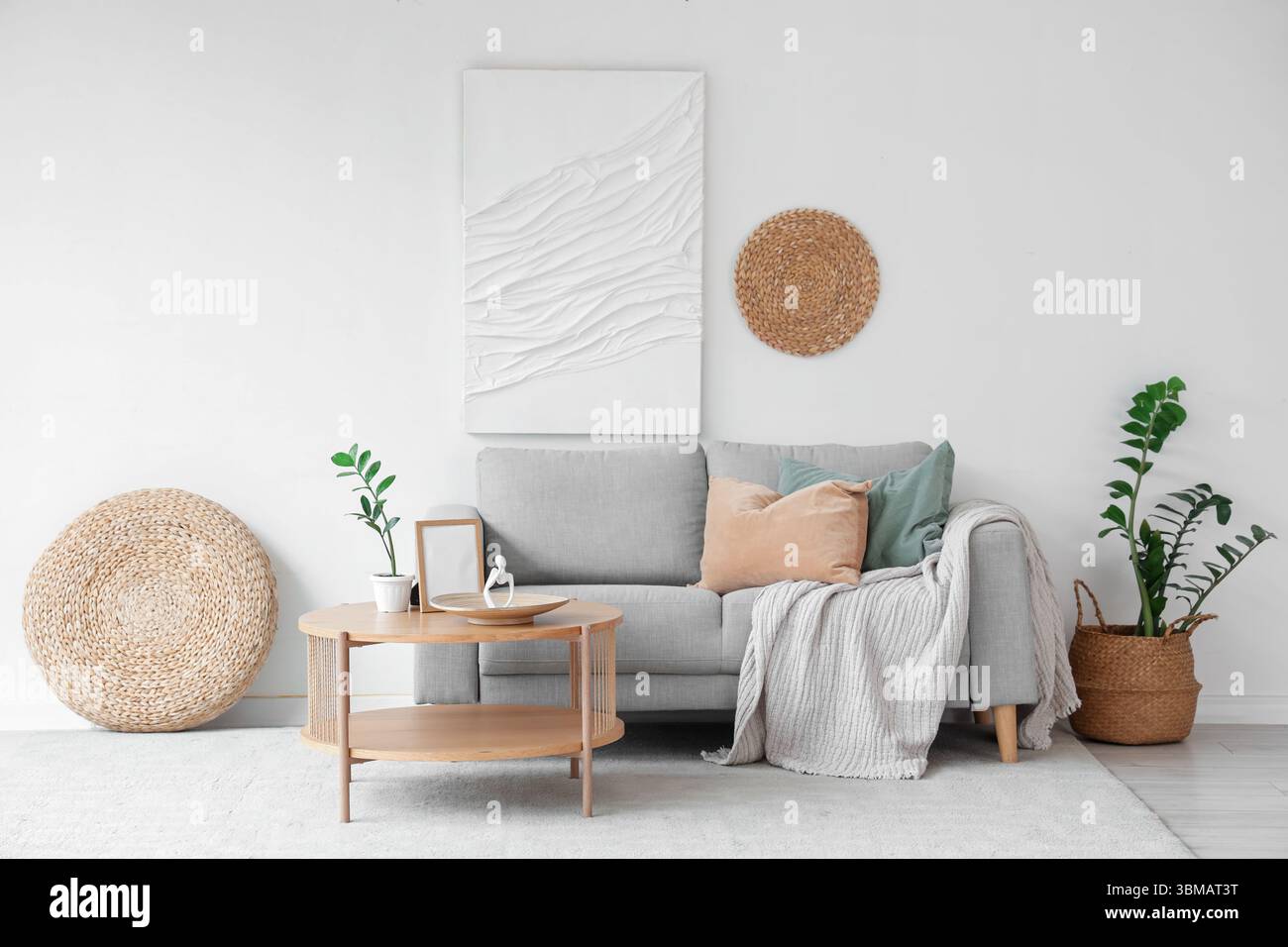 Sofa and wooden coffee table near white wall in interior of living room ...