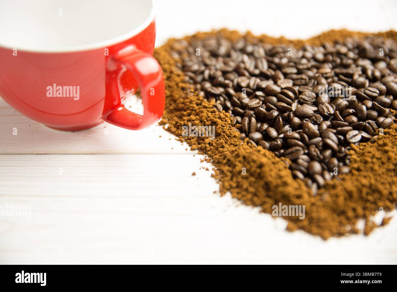 Flat design is showing red ceramic coffee cup on whitewashed wooden table with coffee bean heart Stock Photo