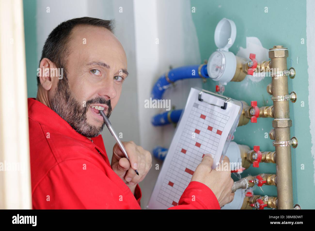 technician reading the water meter to check consumption Stock Photo