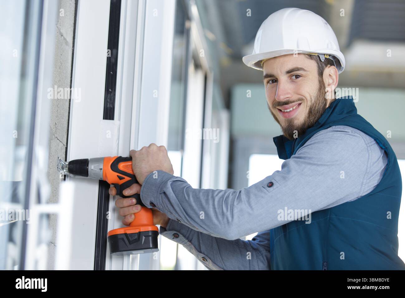 skilled professional using electric drill on the window Stock Photo