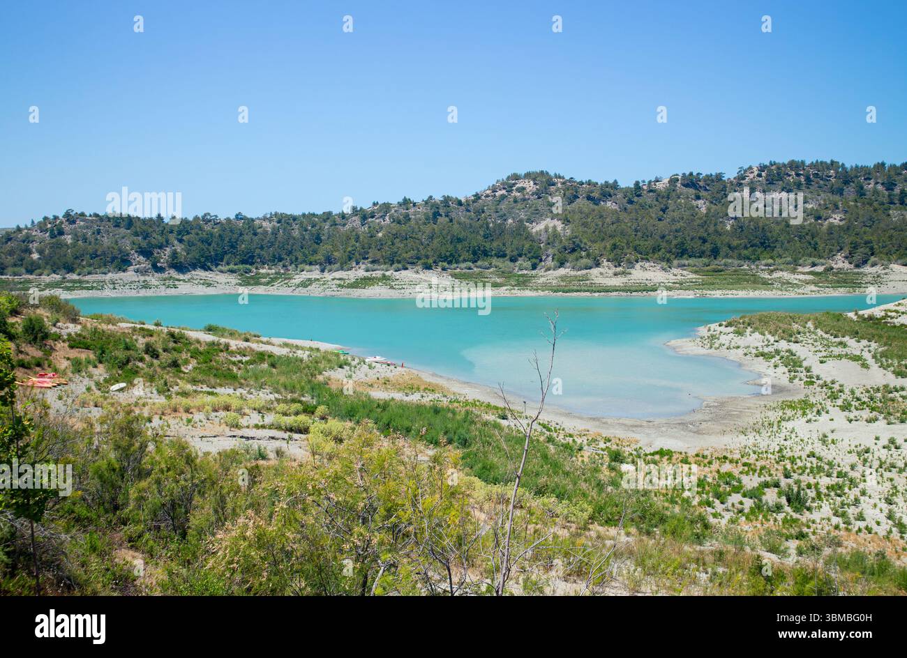 Apolakkia dam lake in Rhodes in Greece. Beautiful blue color Apolakkia Reservoir lake between mountains and forest. Stock Photo