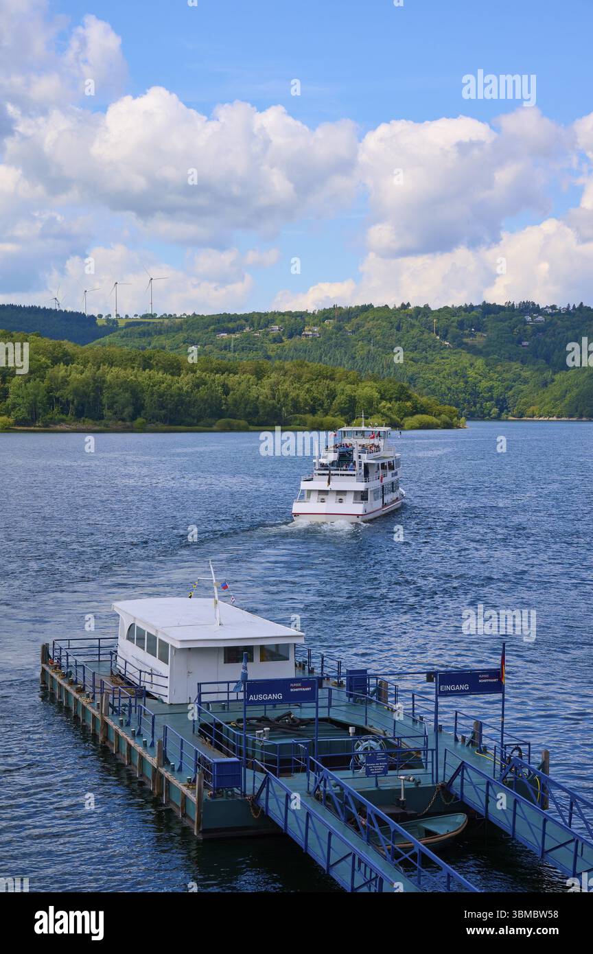 A passenger ship moves away from the landing stage, on a large lake, summer, Rursee, Rurtalsperre, Heimbach, Simmerath, Eifel National Park, North Rhi Stock Photo