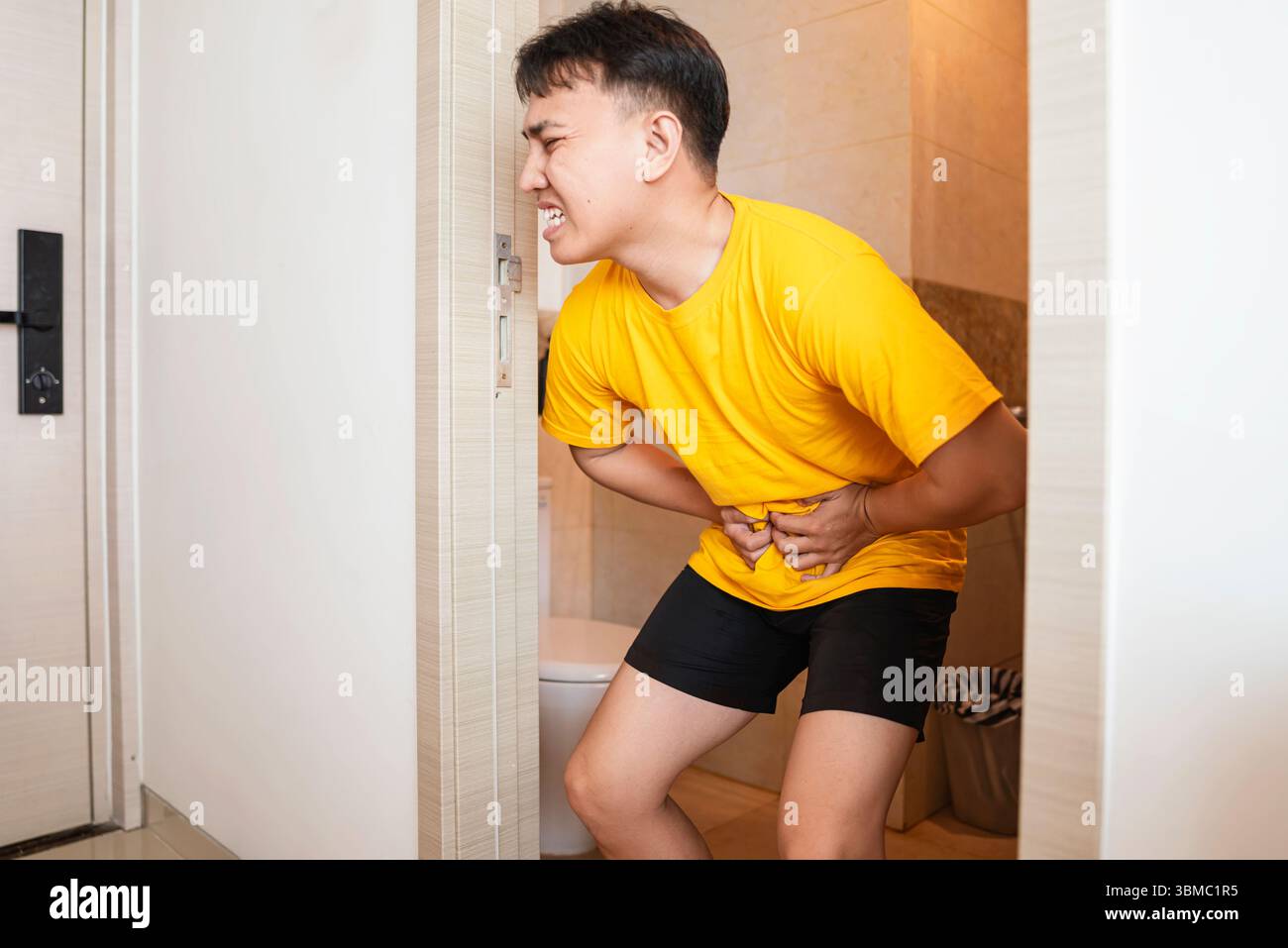 Indonesian southeast asian man suffering from a stomach ache, diarrhea ...