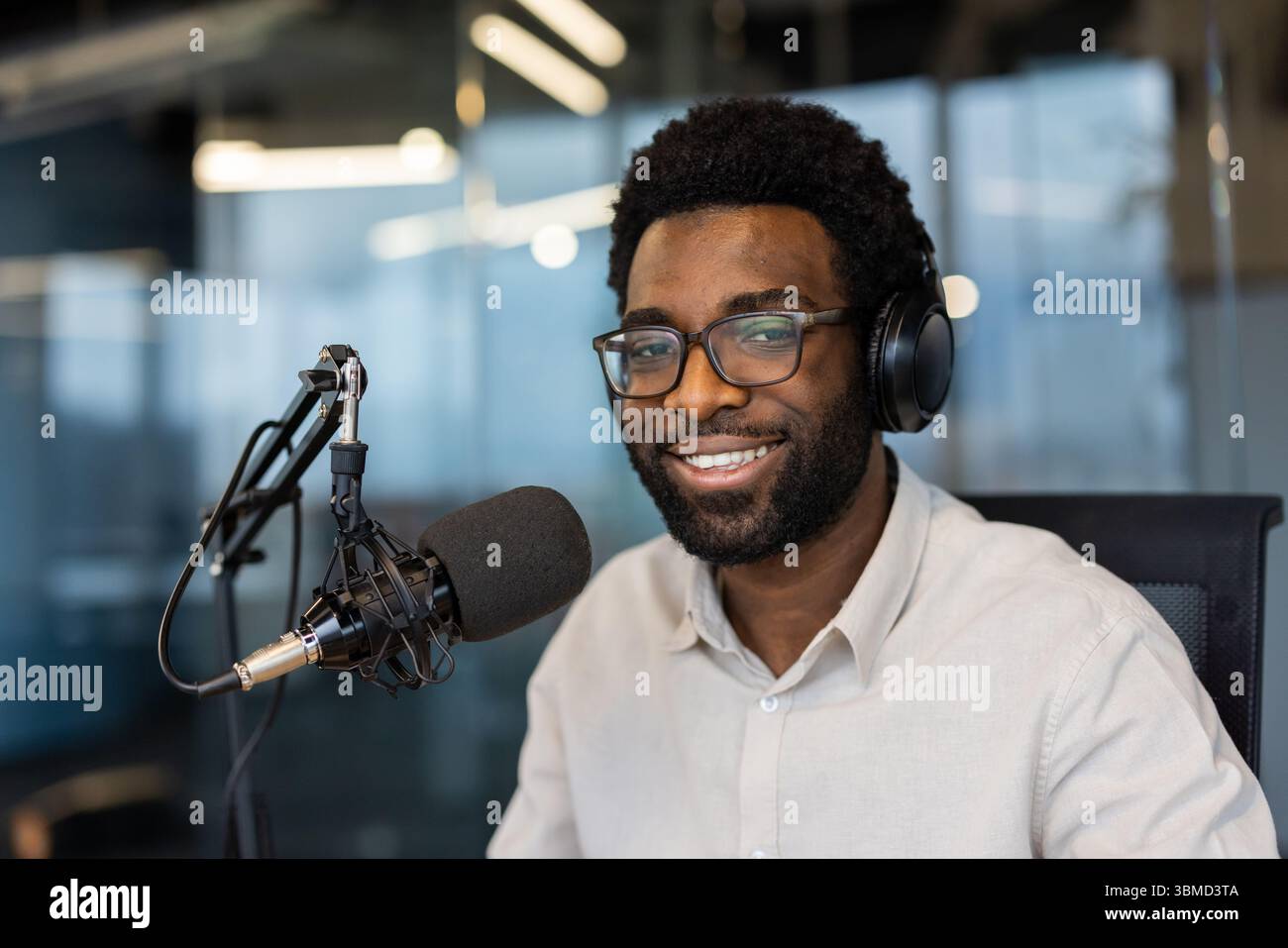 Studio Speaking A smiling man with glasses and headphones at a recording studio ...