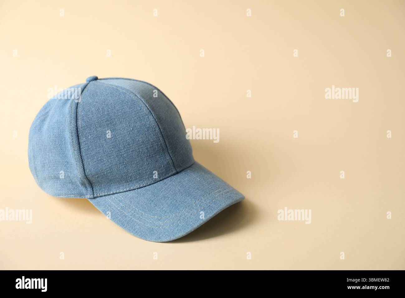 Denim baseball hat on beige background, space for text Stock Photo