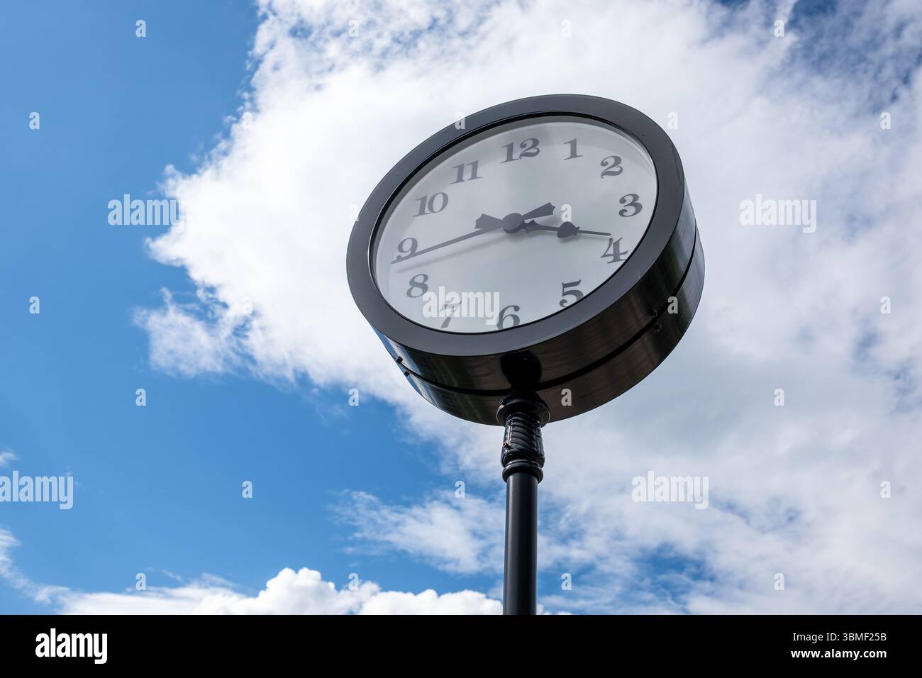 Vintage Clock Mounted on a Pole Against a Bright Blue Sky During the ...