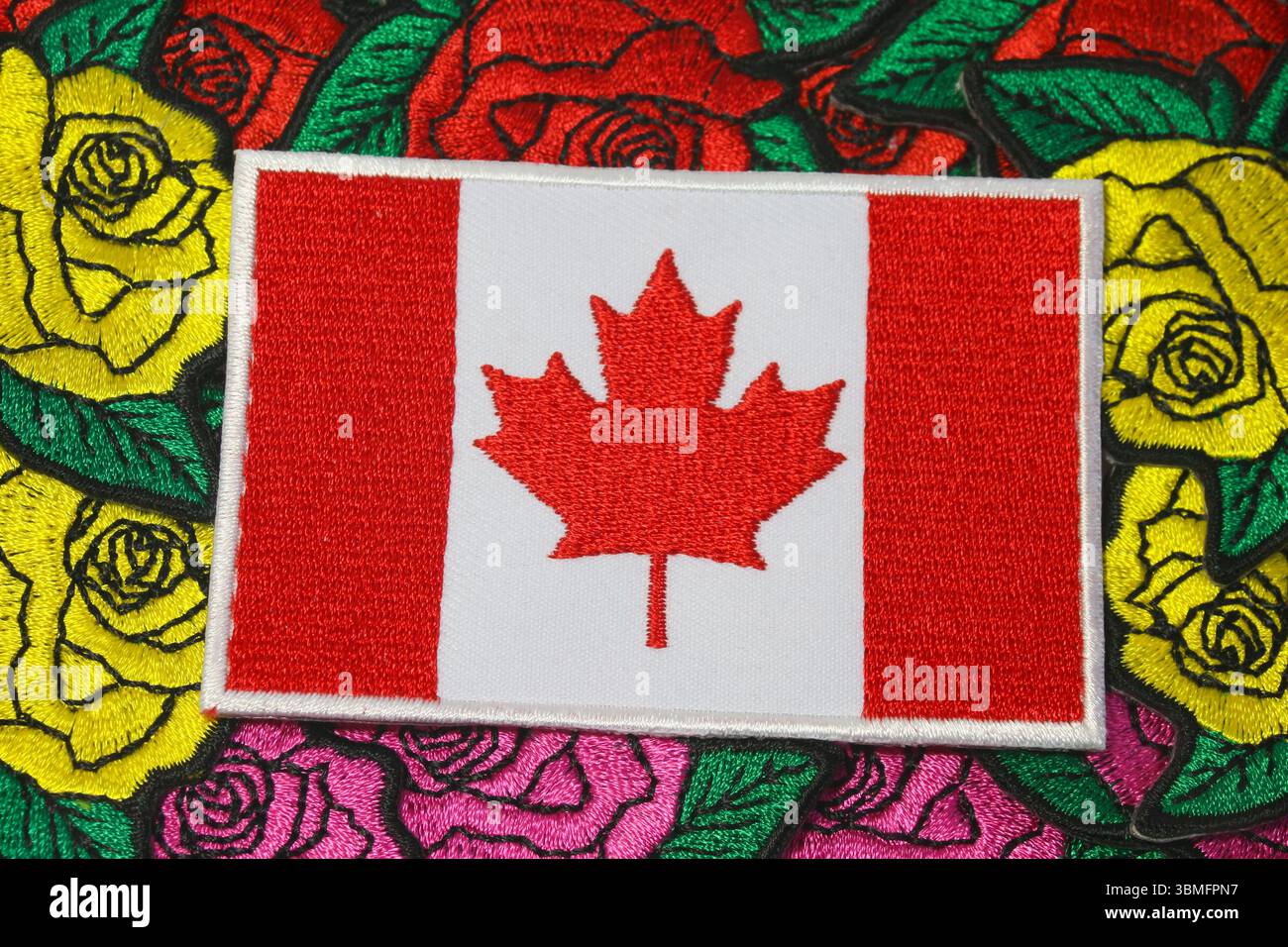 Embroidered Canada flag on colorful handmade rose textile, symbolizing eco friendly craft and cultural pride. Stock Photo