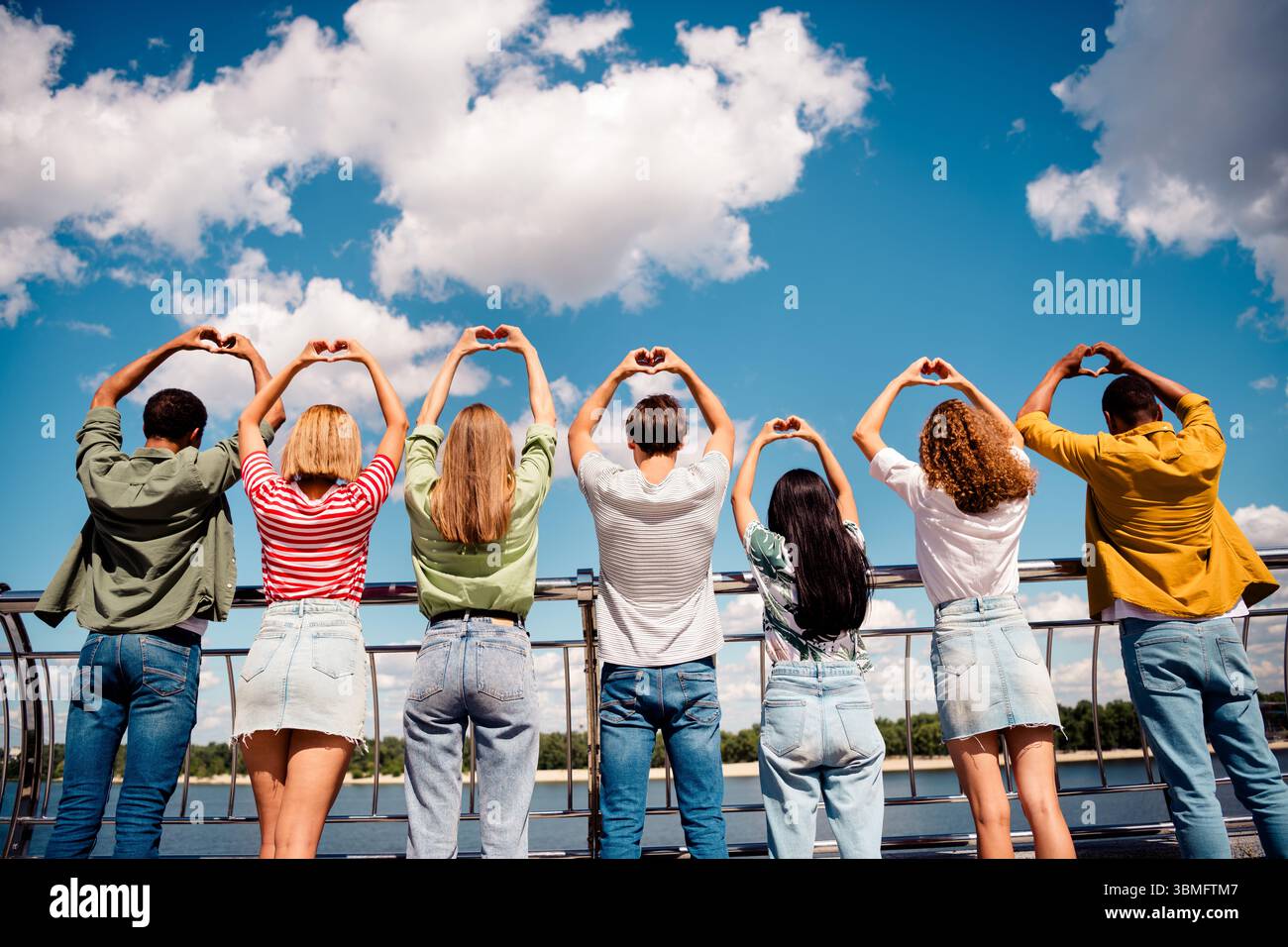 Group of young friends outdoors showing heart gestures on a sunny day ...