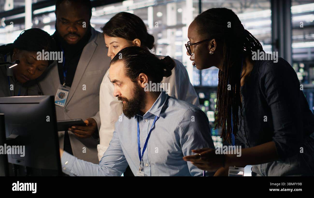 Admins doing brainstorming in server hub, reviewing machine learning code and LLM visualization dashboards. Data center IT experts using computer to monitor AI infrastructure performance, camera A Stock Photo