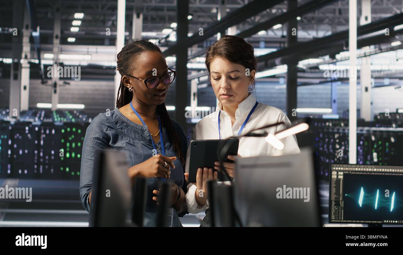 Data center teamworking colleagues performing maintenance on server ...