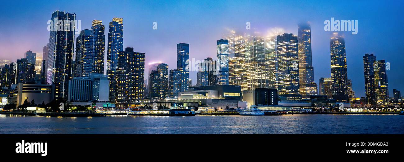 New York City skyline at night - The Battery river tour - NYC building skyscraper lights in evening on the East River - Stock Photo