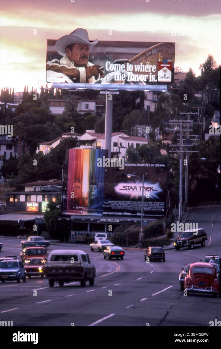 The Sunset Strip in Los Angeles at sunset in 1979 with hand-painted billboards promoting Star Trek, the Movie, and Marlboro cigarettes above the steady flow of traffic in Los Angeles, California, USA Stock Photo