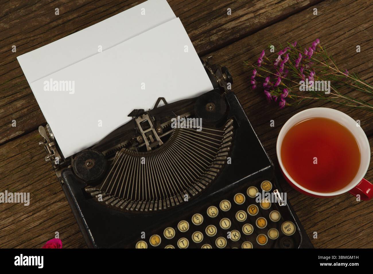 Typewriter and flowers on table Stock Photo