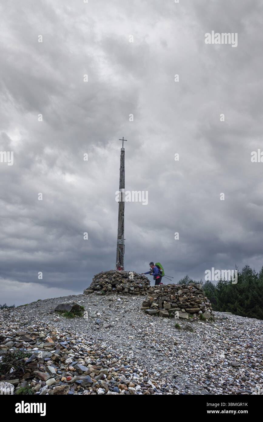 Pilgrim on the Camino de Santiago offering votive stones and offerings ...