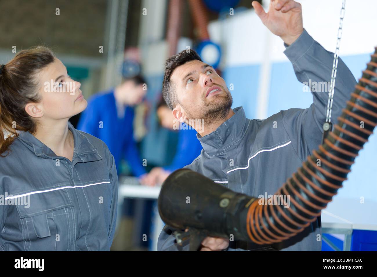 service man and female apprentice checking a ventilation tube Stock Photo
