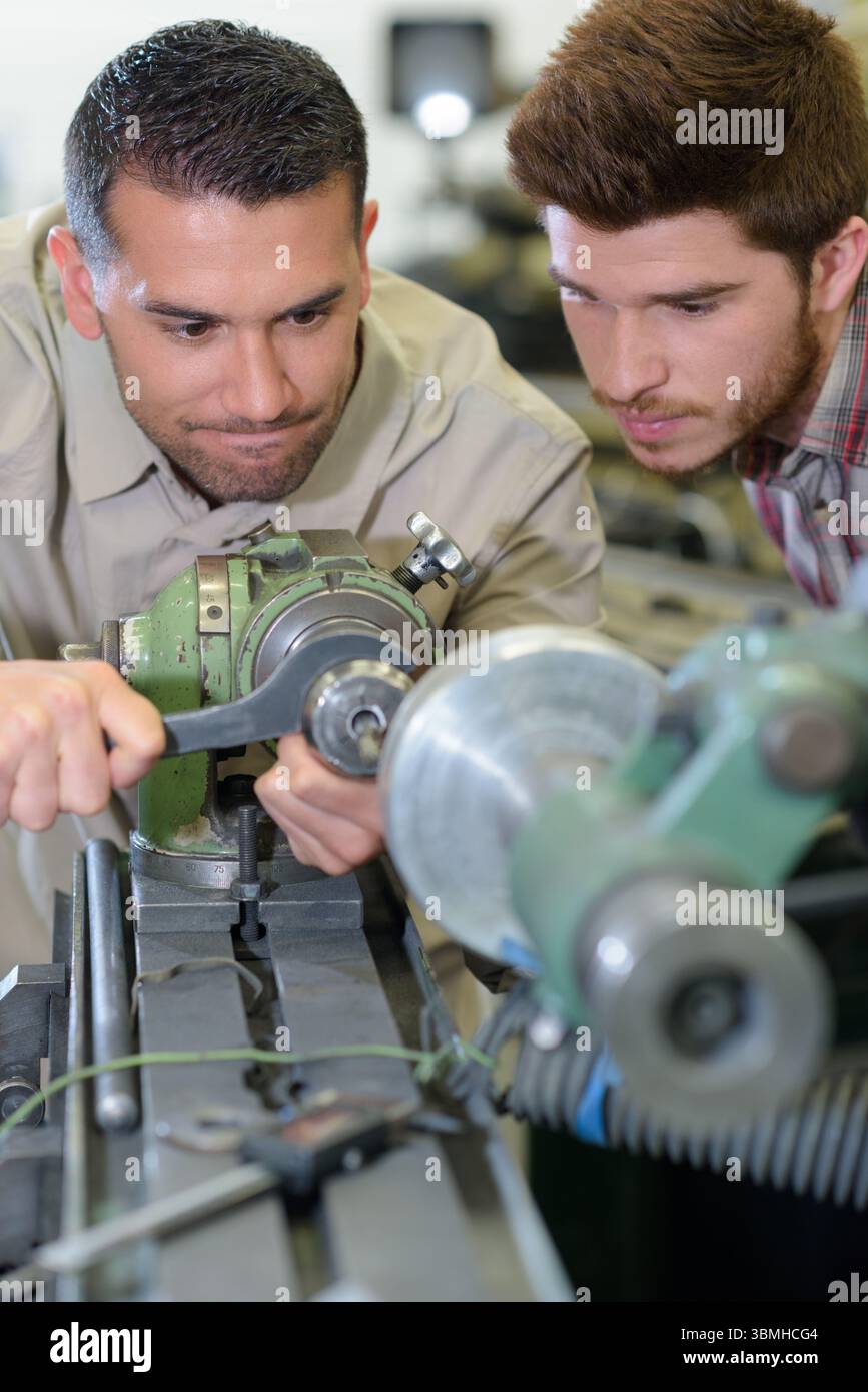 mechanic showing parts of an engine to apprentices Stock Photo