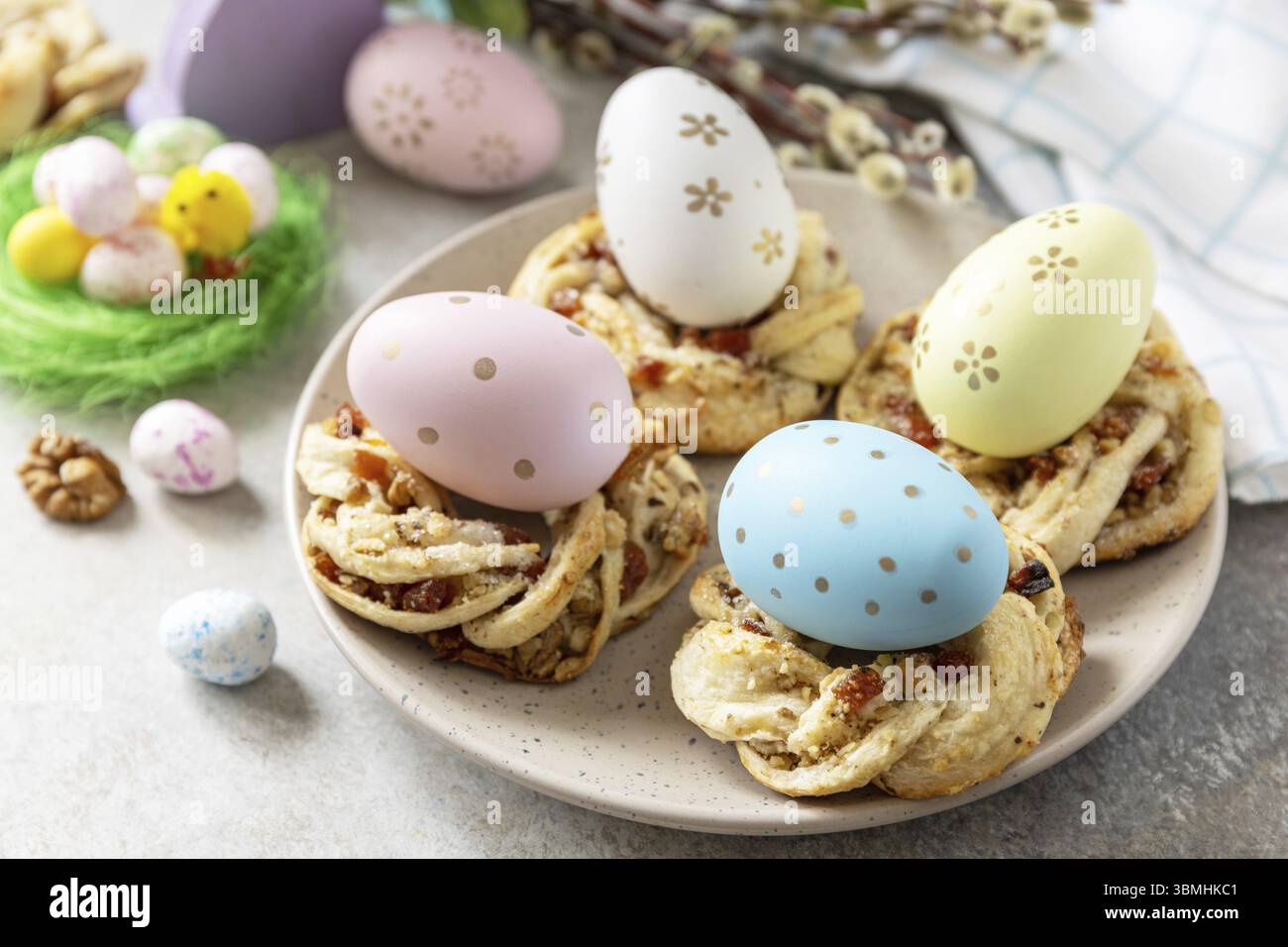 Easter composition. Sweet Italian Easter Bread Rings from puff pastry and dyed eggs on a stone background Stock Photo