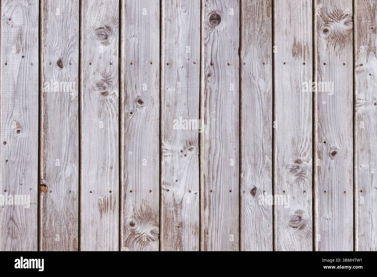 Vertical weathered planks are forming full-frame flat design showing grain and nail holes Stock Photo