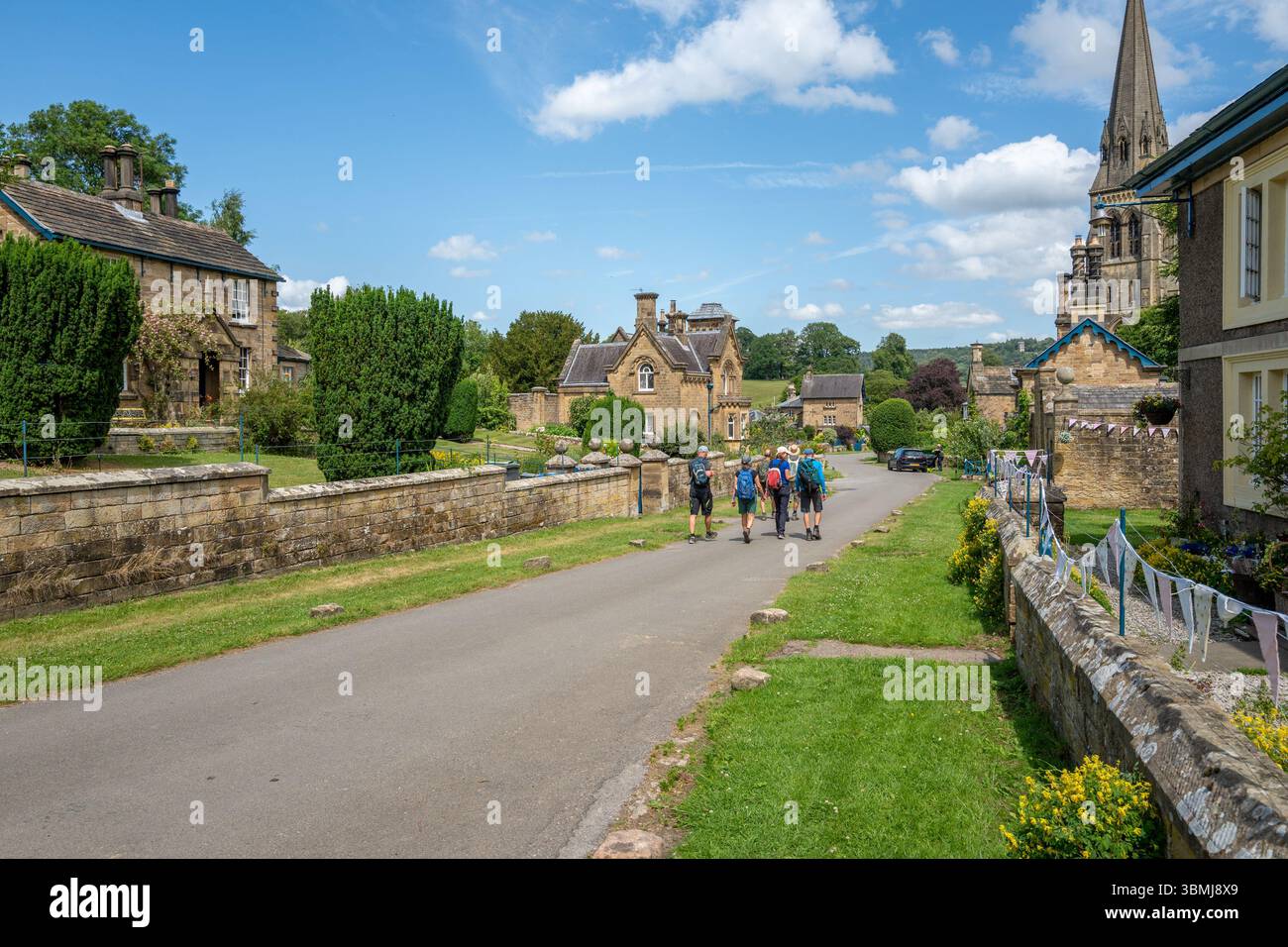 Group of walkers walking through the Derbyshire village of Edensor ...