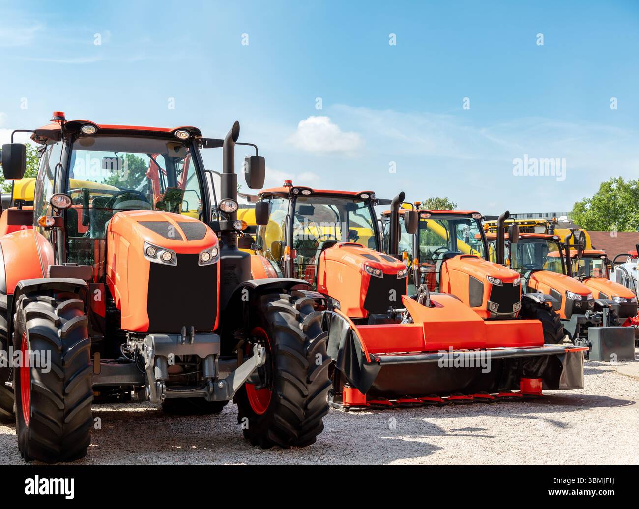 Equipment dealership lot with orange tractors in a row Stock Photo