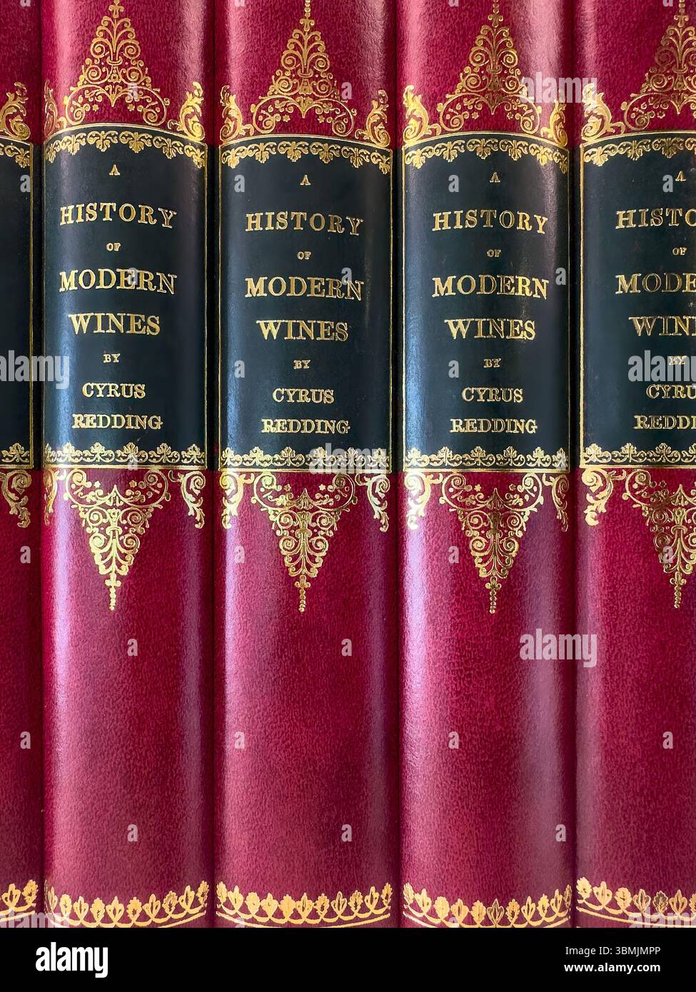 Close-up of red and gold vintage ornate book spines covers  titled 'A History of Modern Wines' by Cyrus Redding - Smartphone Captured Stock Image