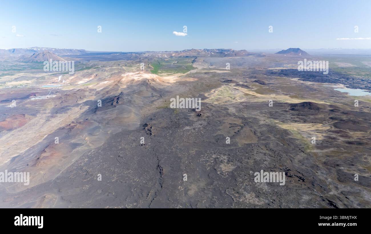 Experience the majestic Hverfjall Volcano, showcasing its unique volcanic terrain and rich geological features with the stunning Icelandic landscape in the background under clear blue skies. Stock Photo