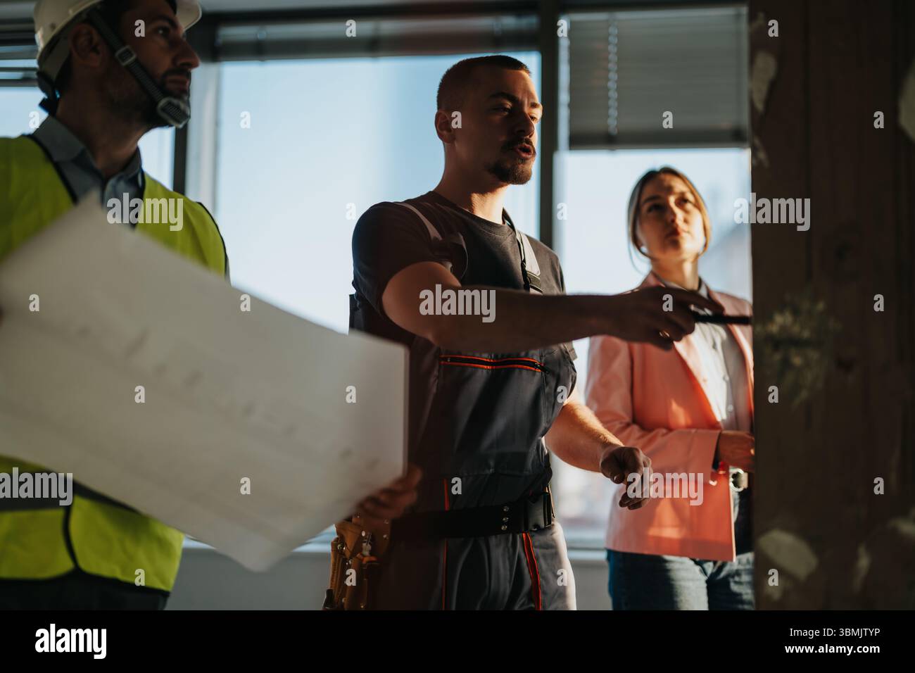 Team of construction professionals collaborating on a project inside a modern building Stock Photo