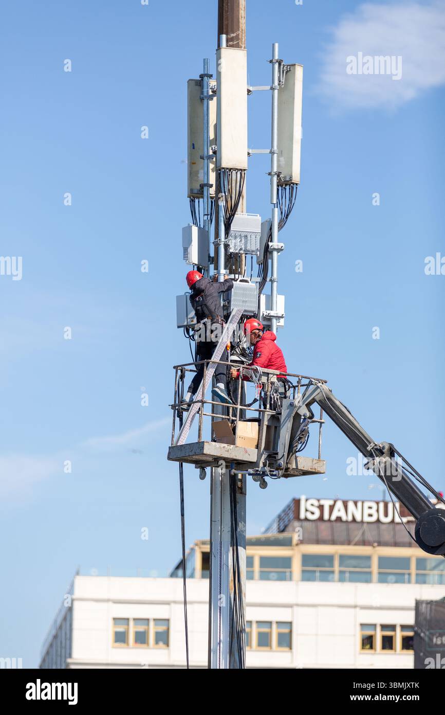 Istanbul, Turkiye - May 12, 2025: Two workers working on the GSM ...