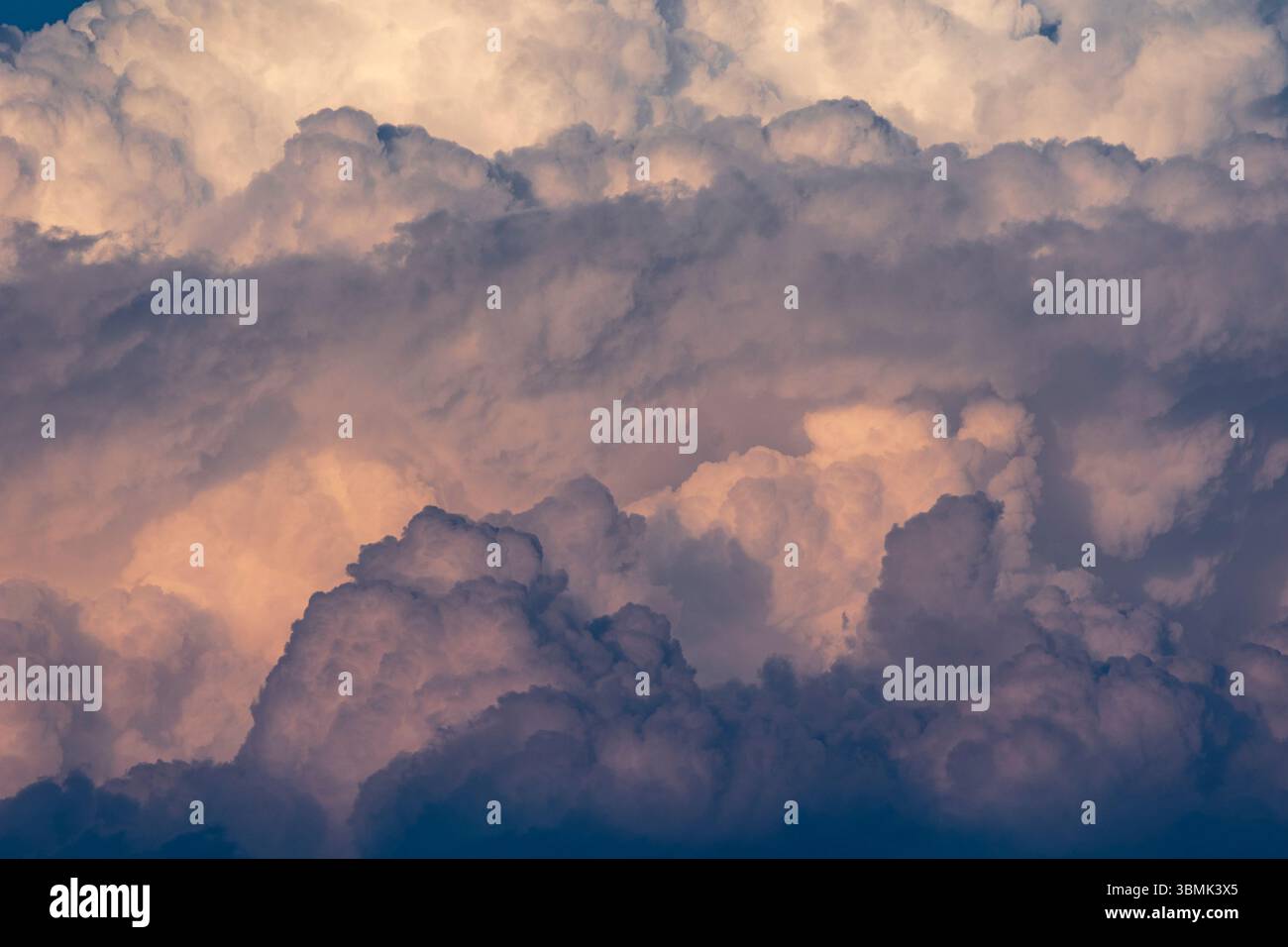 Closeup abstract image of big fluffy clouds in the sky with blue and orange hues and texture Stock Photo