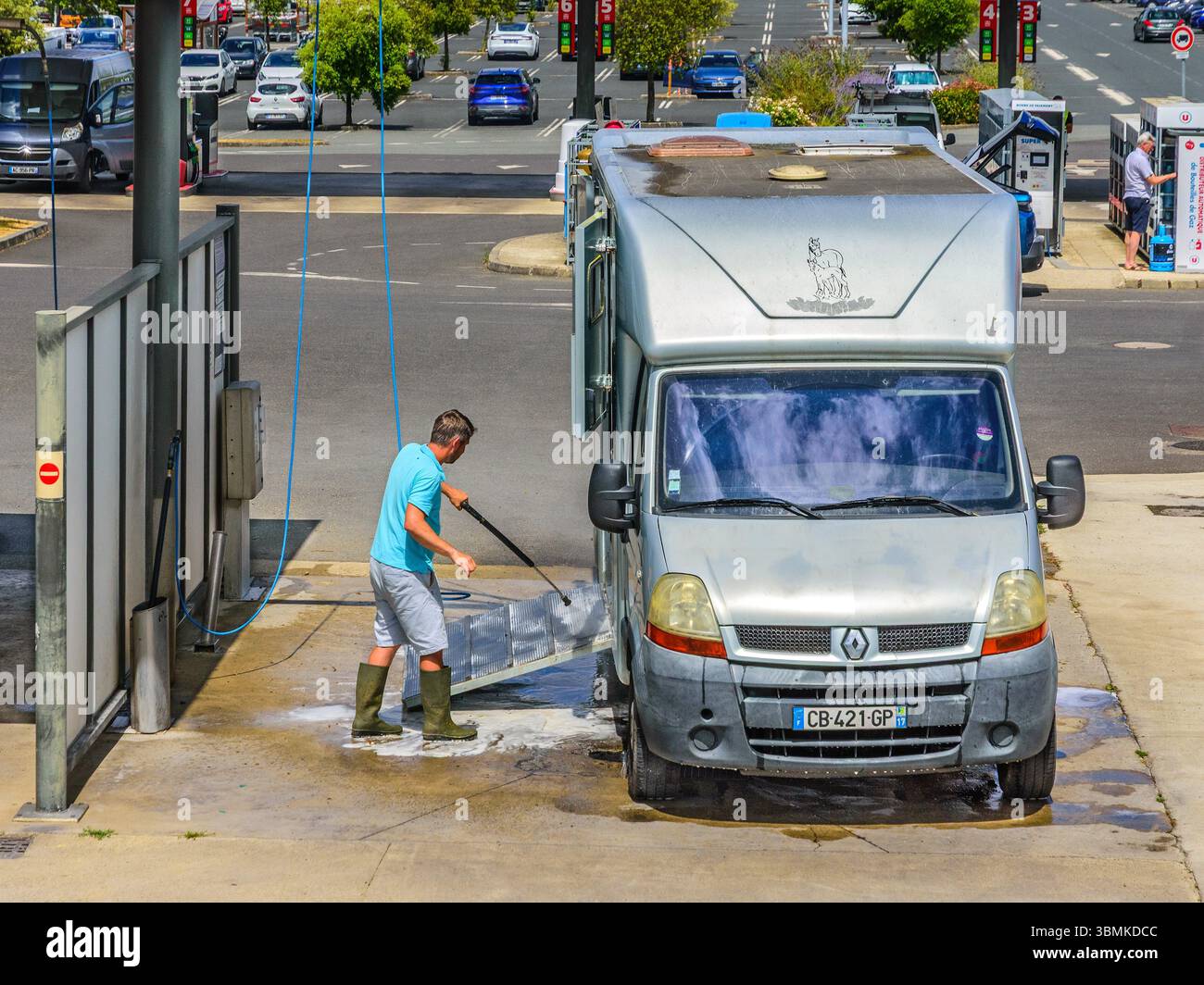 Man using a water jet to clean his horse box transporter - Loches, Indre-et-Loire (37), France. Stock Photo