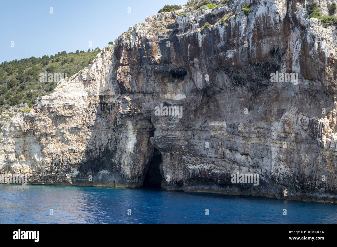 mediterranean sea caves, rugged cliff face, deep blue water, limestone ...