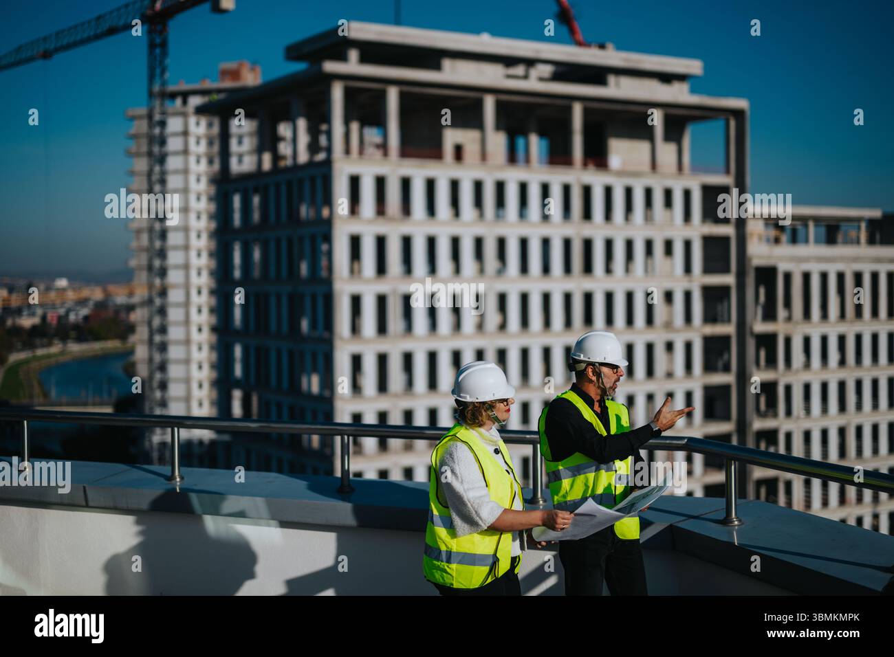 Architects discussing building plans at a construction site Stock Photo