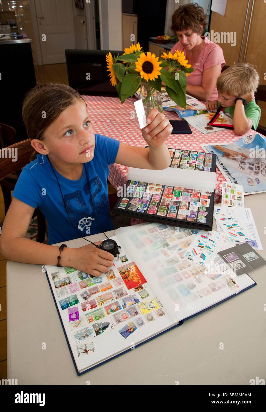 Netherlands, Arnhem, Girl looks at her stamp collection. Philately is the study and collecting of stamps. Stock Photo