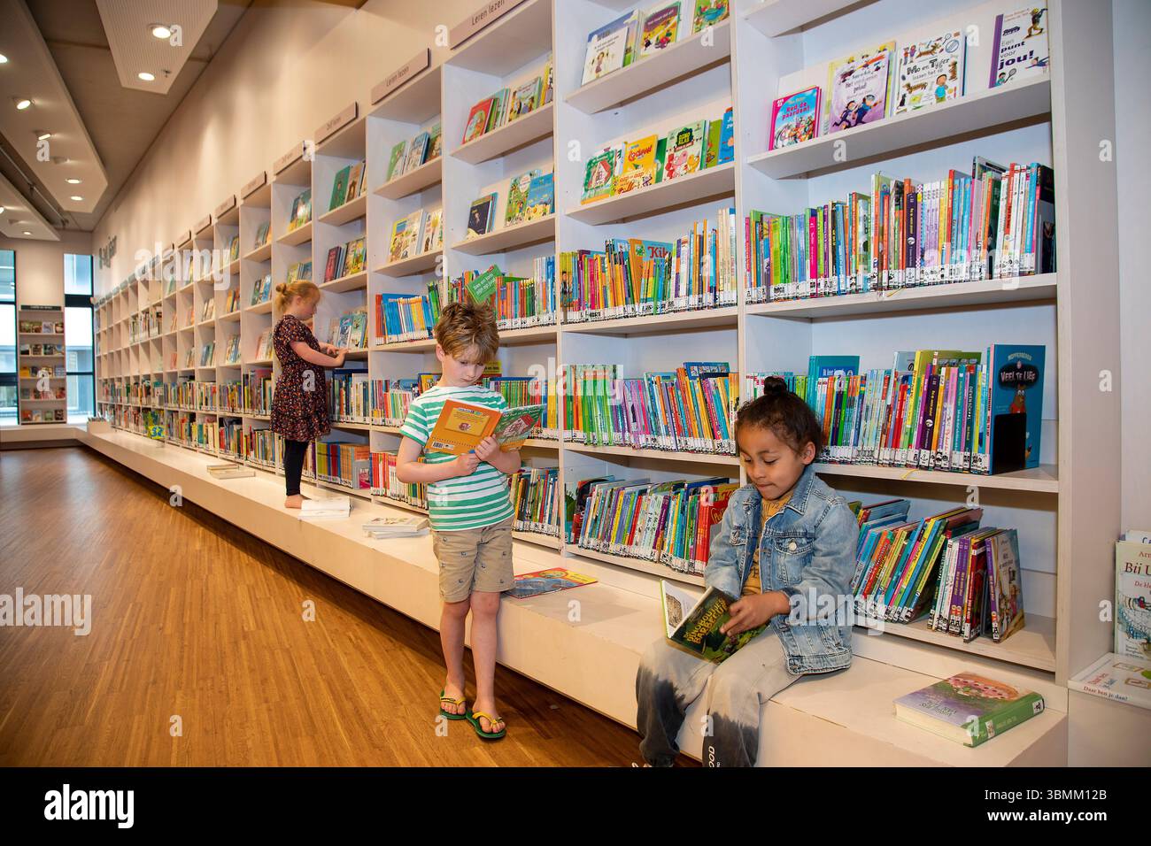 Netherlands, Children reading books in a public library Stock Photo - Alamy