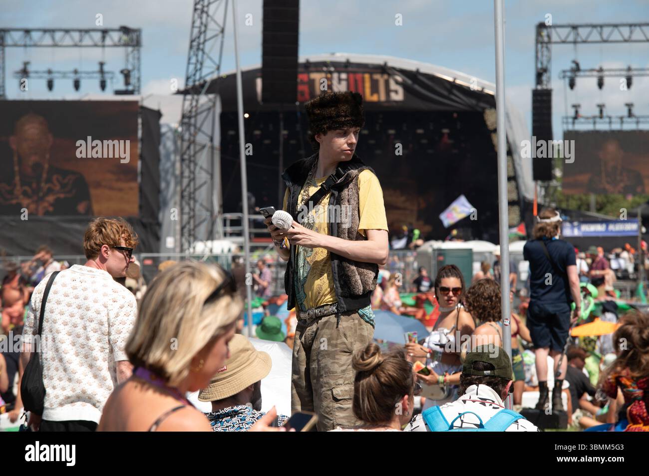 Worthy Farm, Somerset, United Kingdom. 27th June 2025. Festival goer using a portable fan to defend himself from the heatwave at Glastonbury 2025. Cristina Massei/Alamy Live News Stock Photo