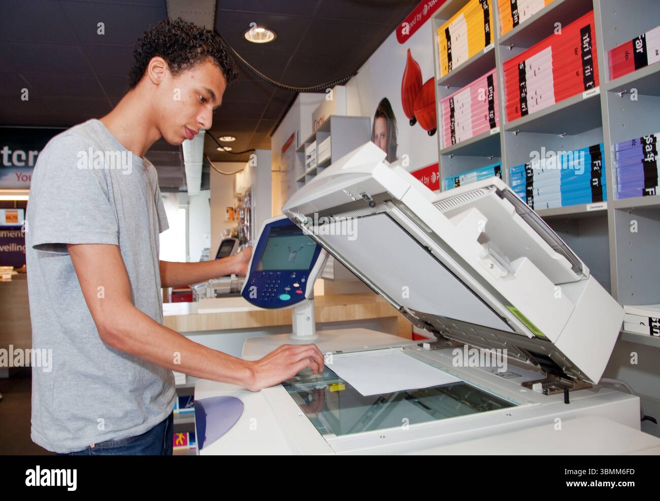 Netherlands. man is using a copy machine in a copyshop to reproduce some text. Stock Photo