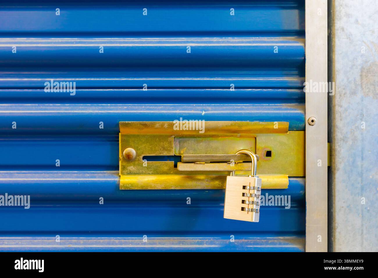 Combination lock securing door on self storage unit. Stock Photo