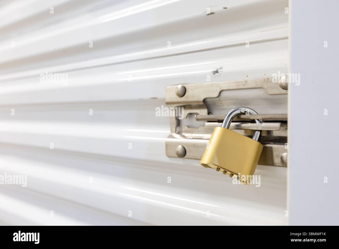 Combination lock securing door on self storage unit. Stock Photo