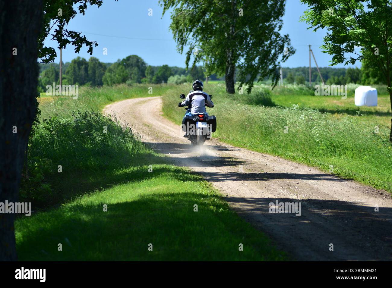 Motorcyclist rides an adventure touring motorcycle on a gravel ...