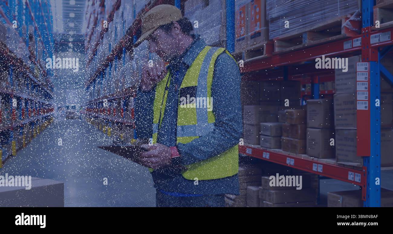 Inspecting warehouse worker checking inventory in warehouse aisle with tablet and boxes, copy space Stock Photo