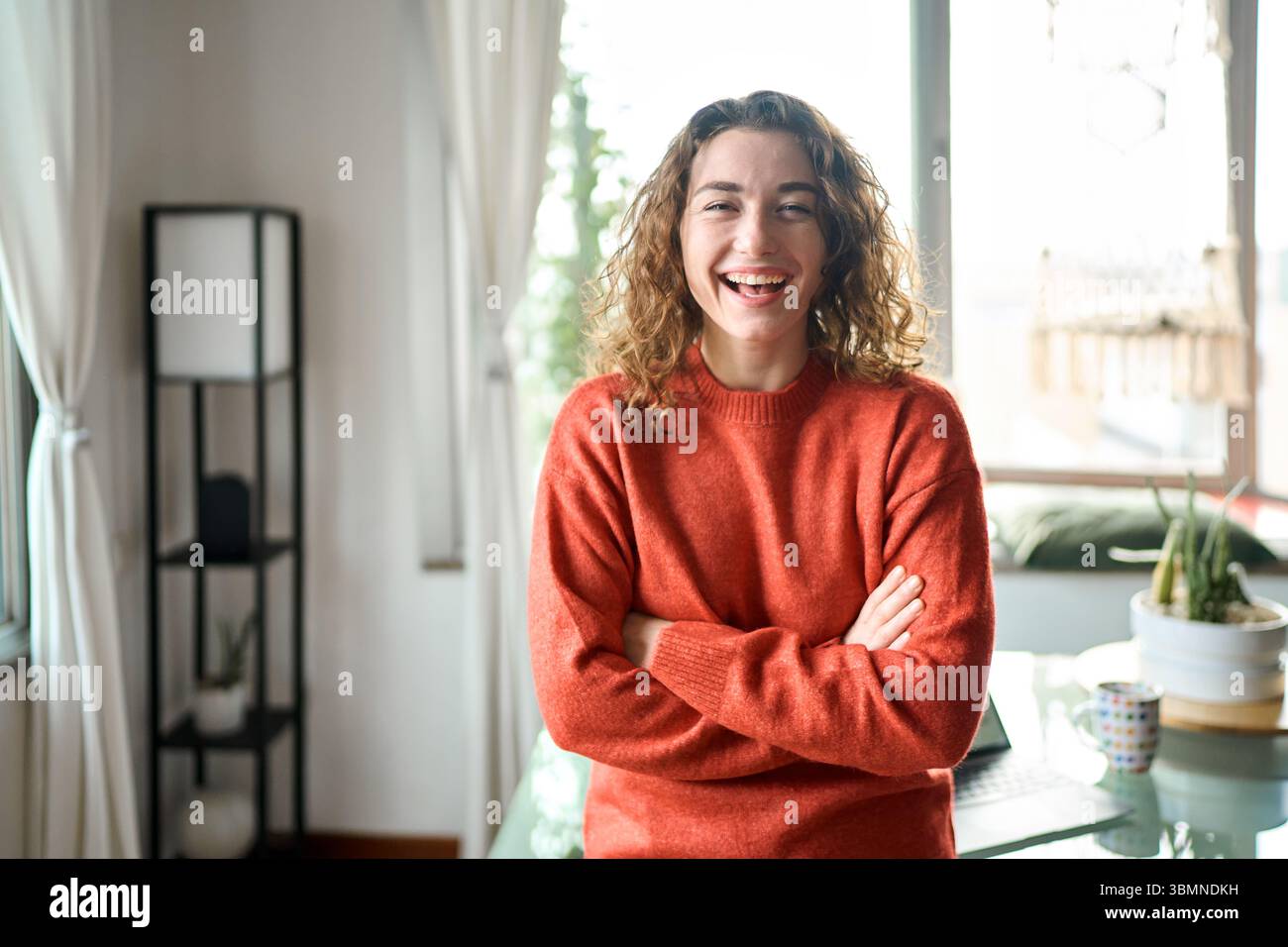 Young smiling pretty lady having fun feeling joyful at home looking at camera. Stock Photo
