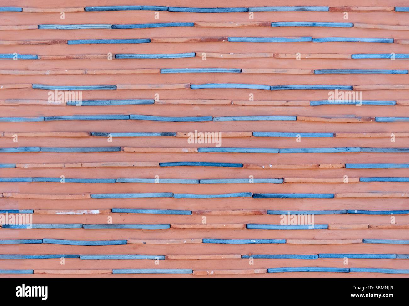 horizontal ceramic wall in Seoul with alternating blue and terracotta bars, forming a seamless pattern with organic texture and soft color contrast. Stock Photo