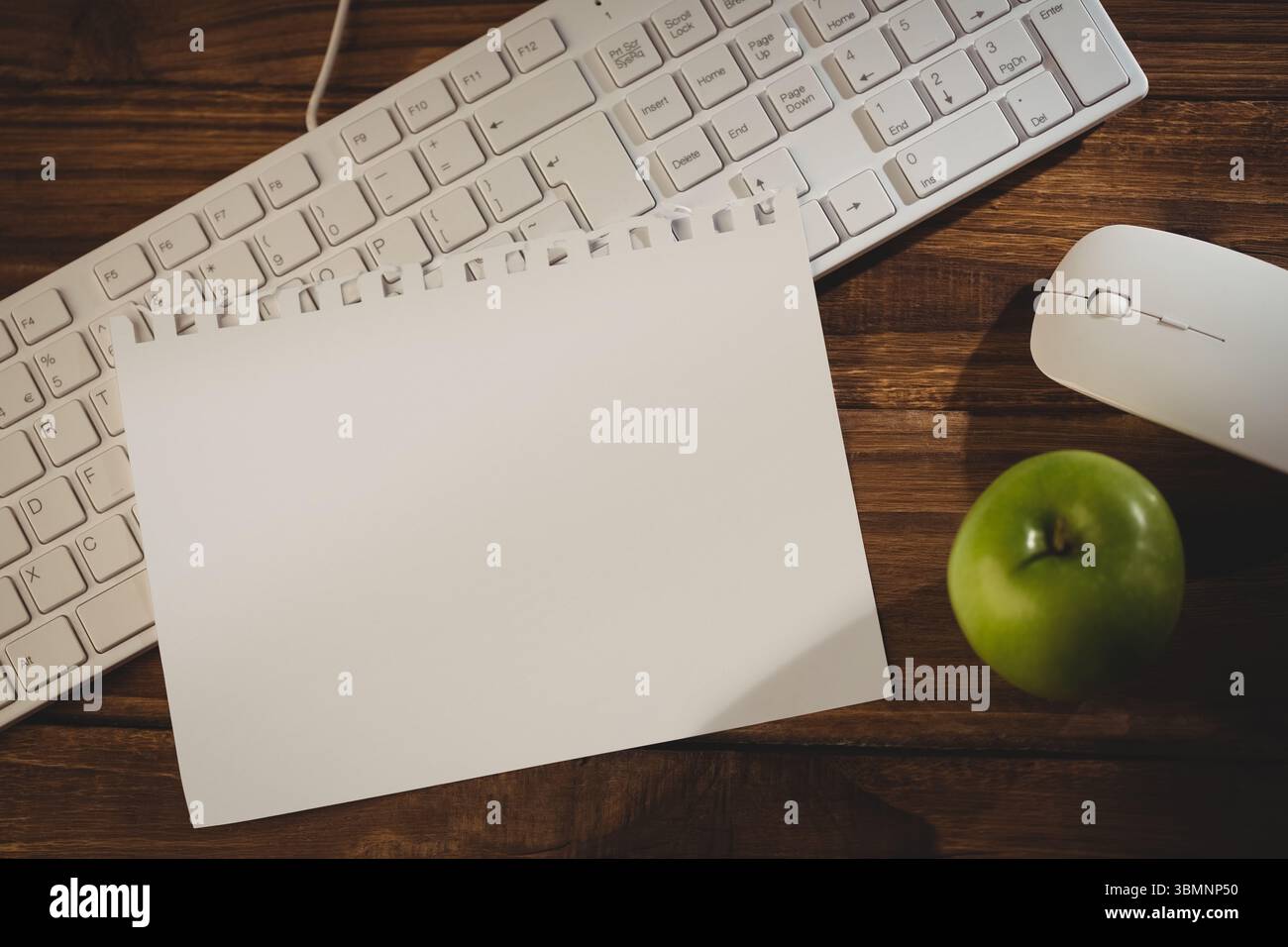 Keyboard with mouse and green apple on table Stock Photo