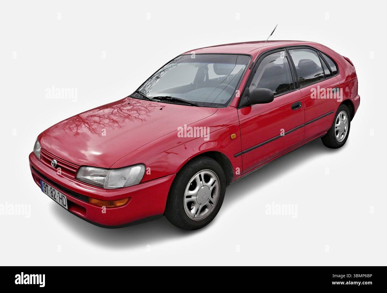 Red Toyota Corolla E100 Hatchback parking on a white background, showcasing its classic design Stock Photo
